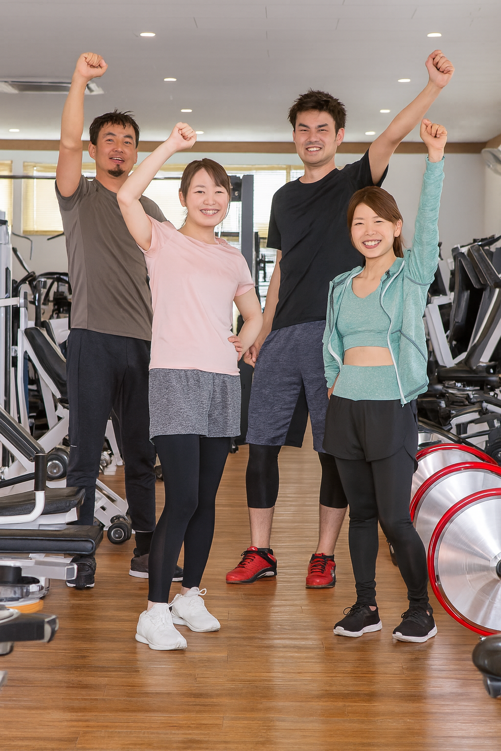 男女4人のトレーナーが笑顔でジャンプしている様子
